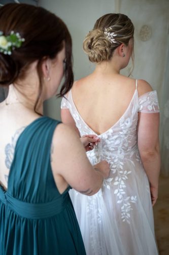 Brautjungfer hilft Braut beim anziehen